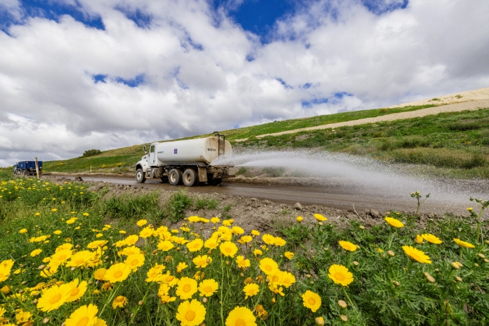 A water truck is spraying the landfill roads to keep dust and air pollution at bay.